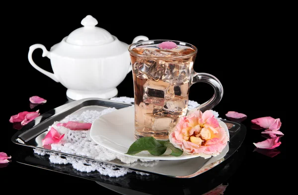 Glass cup of ice tea from tea rose on metallic tray on napkin on black background — Stock Photo, Image