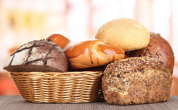 Brot gebacken in Weidenkorb auf Fensterhintergrund — Stockfoto
