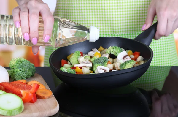 Manos cocinando ragú de verduras en sartén en la cocina — Foto de Stock