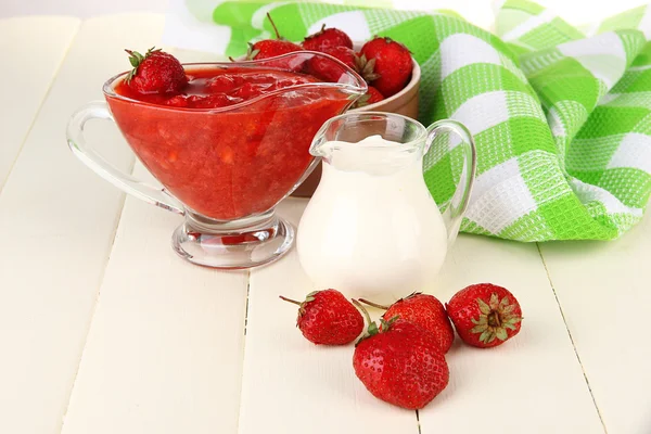 Homemade strawberry jam, on napkin, on color wooden background — Stock Photo, Image