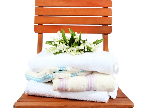 Handdukar och blommor på trä stol isolerad på vit — Stockfoto
