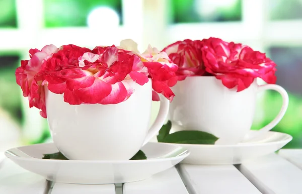 Rosas en copas sobre mesa sobre fondo de ventana —  Fotos de Stock