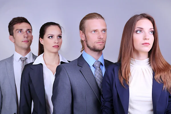 Obchodní tým stojící v řadě na šedém pozadí — Stock fotografie