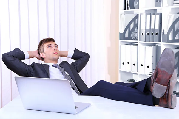 Empresario descansando en su oficina con sus zapatos en la mesa — Foto de Stock