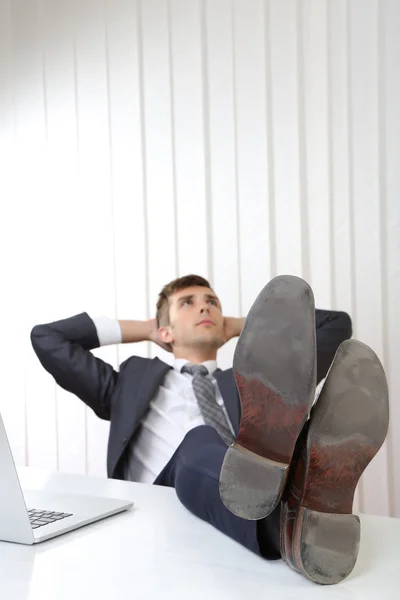 Zakenman rusten op zijn kantoor met zijn schoenen op tafel — Stockfoto