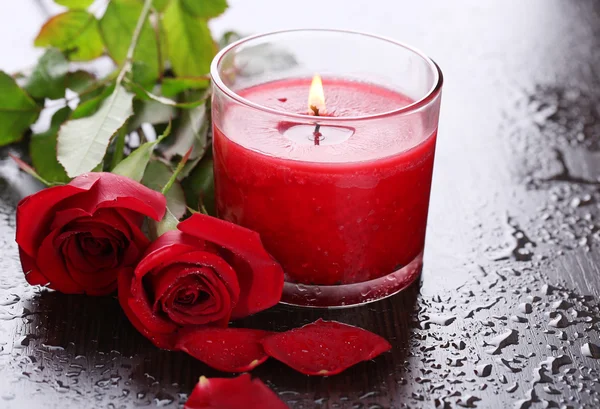 Beautiful romantic red candle with flowers, close up — Stock Photo, Image