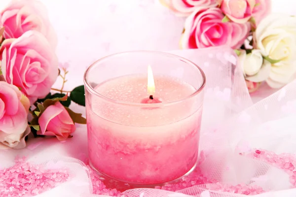 Schöne Kerze mit Blumen auf weißem Tuch, Nahaufnahme — Stockfoto