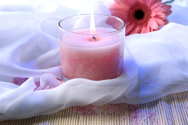 Beautiful candle with flower on white cloth, close up — Stock Photo, Image