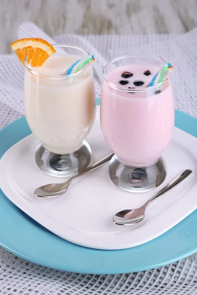 Delicious milk shakes with orange and blackberry on wooden table close-up — Stock Photo, Image