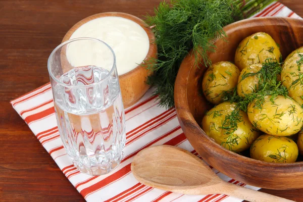 Gekookte aardappelen op houten kom op servet op houten tafel — Stockfoto