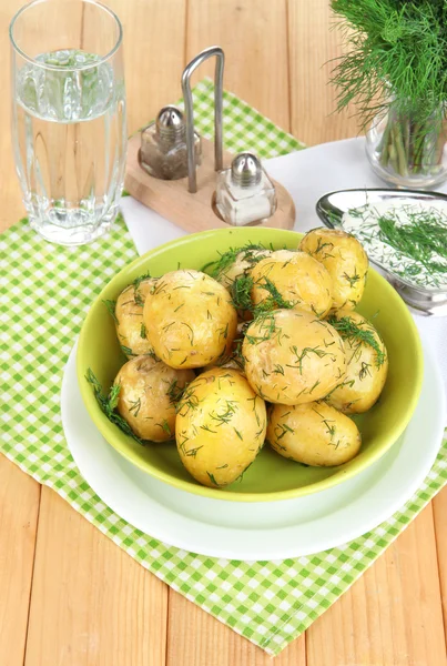 Варёный картофель на тарелках на салфетках на деревянном столе — стоковое фото