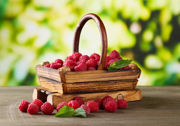 成熟甜树莓在木桌上，在绿色背景上篮 — 图库照片