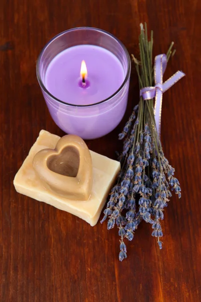 Лавандовая свеча со свежей лавандой, мыло на деревянном фоне — стоковое фото