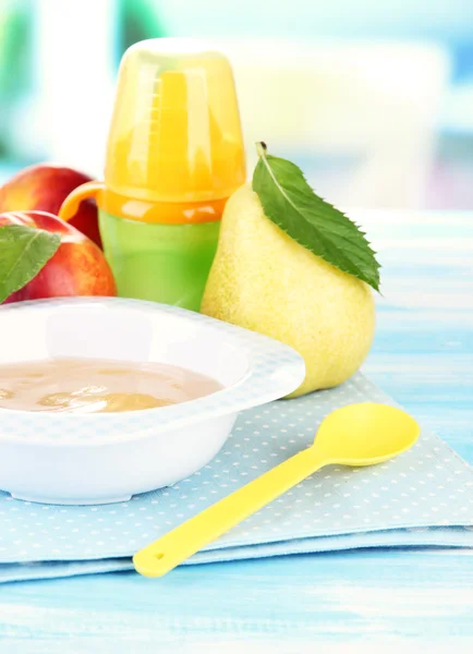 Sabroso puré de frutas y biberón en mesa de madera — Foto de Stock