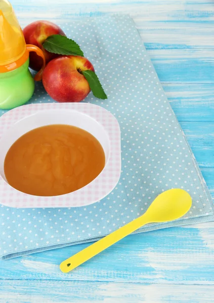 Tasty baby fruit puree and baby bottle on wooden table — Stock Photo, Image