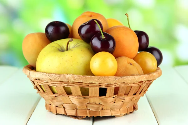 Frutas brillantes de verano en cesta sobre mesa de madera sobre fondo natural —  Fotos de Stock