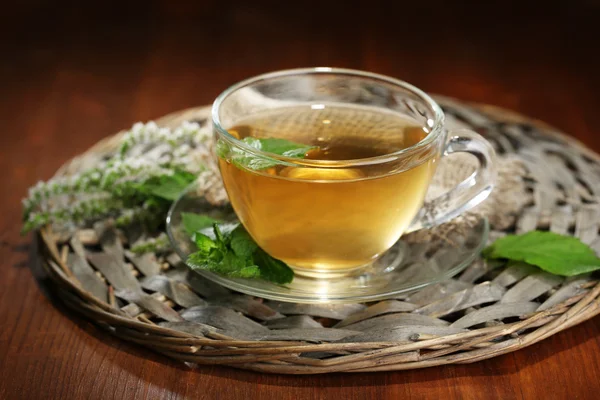 Taza de té de hierbas con flores de menta fresca en la mesa de madera —  Fotos de Stock