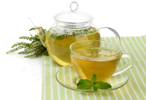 Tetera y taza de té de hierbas con flores frescas de menta aisladas en blanco — Foto de Stock