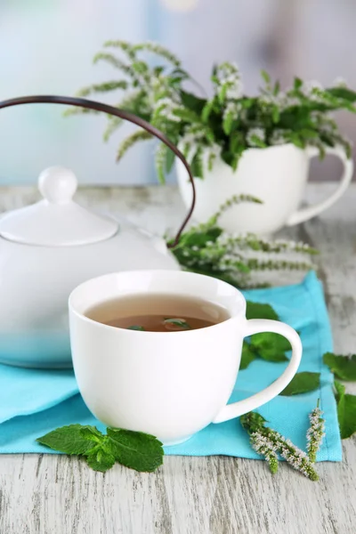 茶壶与杯新鲜薄荷花在木桌上的花草茶 — 图库照片