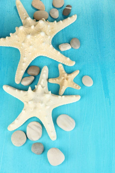 White starfishes on blue wooden table close-up — Stock Photo, Image