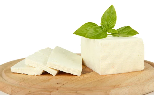 Queso de leche de oveja con albahaca en la tabla de cortar, aislado en blanco — Foto de Stock