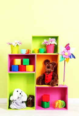 duvar arka plan üstünde toys ile farklı renkteki parlak raflar