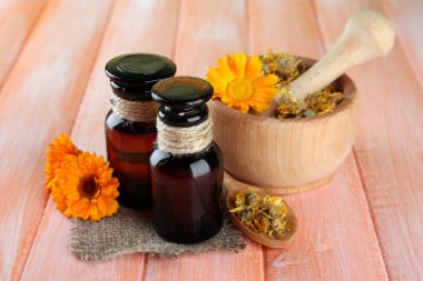 ilaç şişeleri ve ahşap zemin üzerine calendula çiçekler