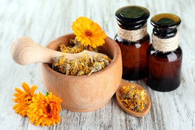 ilaç şişeleri ve ahşap zemin üzerine calendula çiçekler