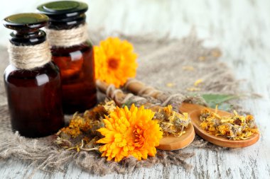 ilaç şişeleri ve ahşap zemin üzerine calendula çiçekler