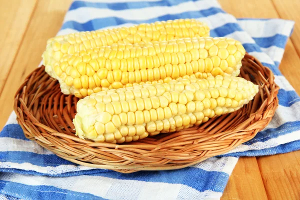 Frischer Mais auf Weidenmatte, auf Holzgrund — Stockfoto