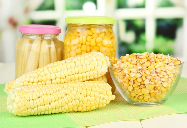 Fresh, canned and dried corn on wooden table, on bright background — Stock Photo, Image