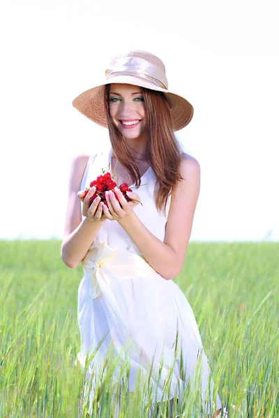 Portret van mooie jonge vrouw met bessen in het veld — Stockfoto