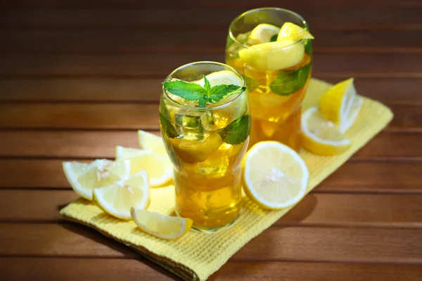 Té helado con limón y menta sobre mesa de madera —  Fotos de Stock