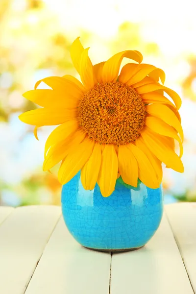 Heldere zonnebloem in vaas op houten tafel op natuurlijke achtergrond — Stockfoto