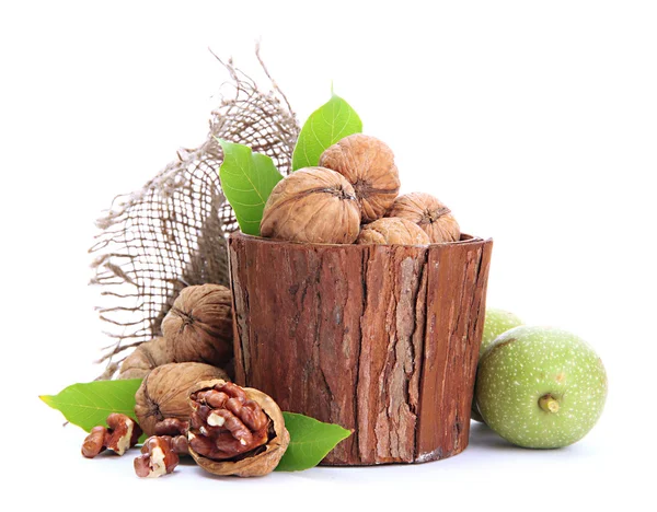 Nueces con hojas verdes en jarrón de madera, aisladas en blanco — Foto de Stock