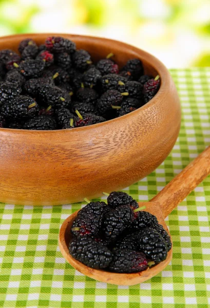 Moras maduras en tazón sobre mesa sobre fondo brillante — Foto de Stock