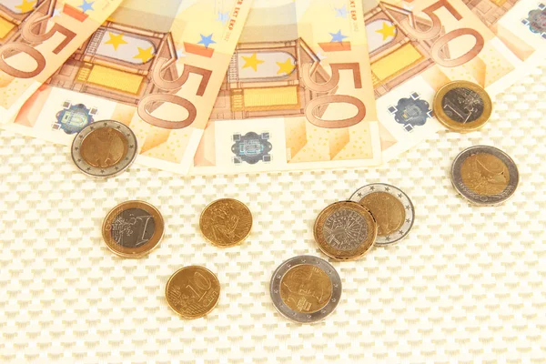 Банкноты евро и центы евро на бежевом фоне — стоковое фото