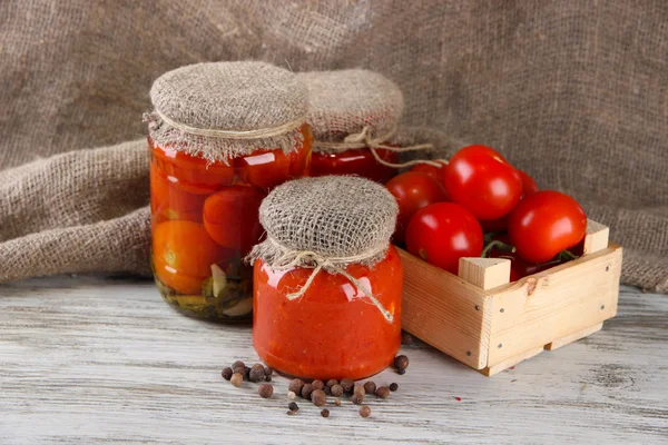 Läckra konserverad och färska tomater på träbord — Stockfoto