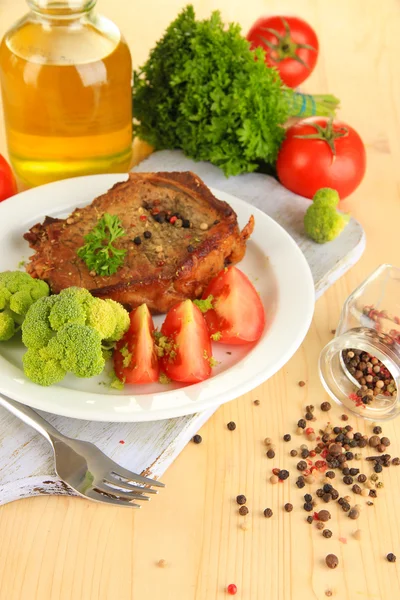 Stekt köttbit på plattan på träbord närbild — Stockfoto