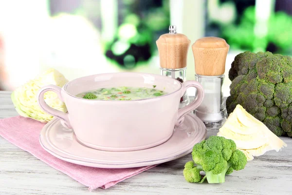 Cabbage soup in plate on napkin on wooden table on window background — Stock Photo, Image