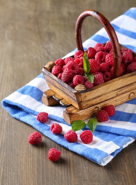 Ripe sweet raspberries in basket on wooden background — Stock Photo, Image