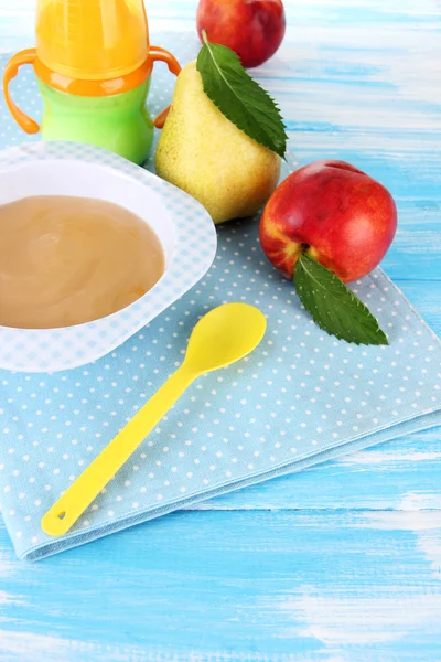 Saboroso purê de frutas do bebê e mamadeira na mesa de madeira — Fotografia de Stock