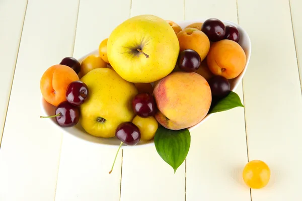 Frutas de verano brillantes en plato en la mesa de madera de cerca — Foto de Stock