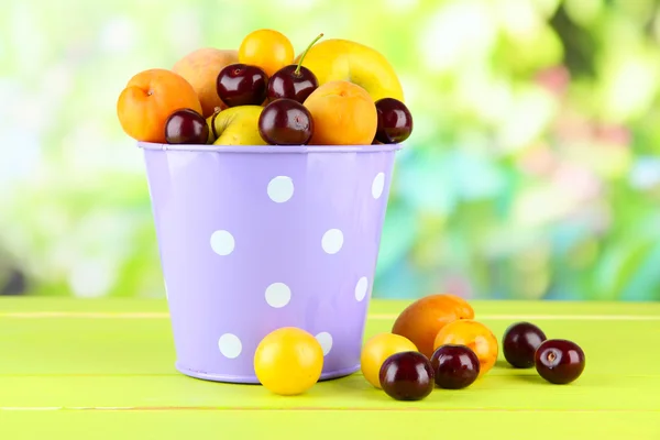 Яскраві літні фрукти в паузі на дерев'яному столі на природному фоні — стокове фото