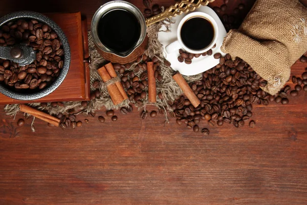 Koffiebonen, metalen turk en koffiemolen op houten achtergrond met kopie ruimte — Stockfoto