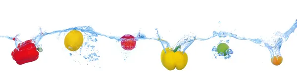 Tropical fruits and vegetables falling into water with splash isolated on white — Stock Photo, Image