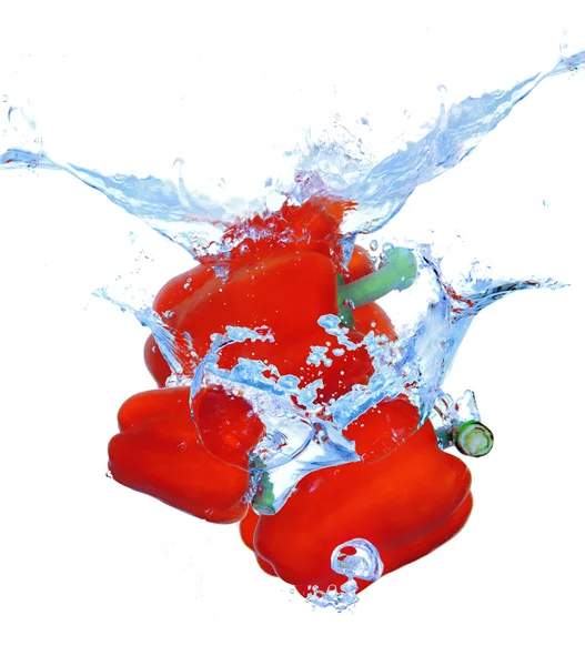 Three peppers falling into water with splash isolated on white — Stock Photo, Image