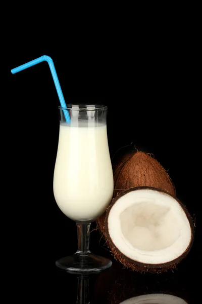 Szklanka mleka kokosowego i kokosy na czarnym tle — Zdjęcie stockowe