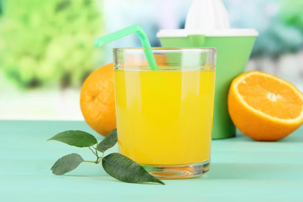 柑橘類を押して、ジュース、緑の木製テーブルに熟したオレンジ色のガラス — ストック写真