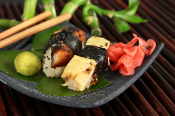 Smakelijke maki sushi - roll op plaat op bamboe mat — Stockfoto